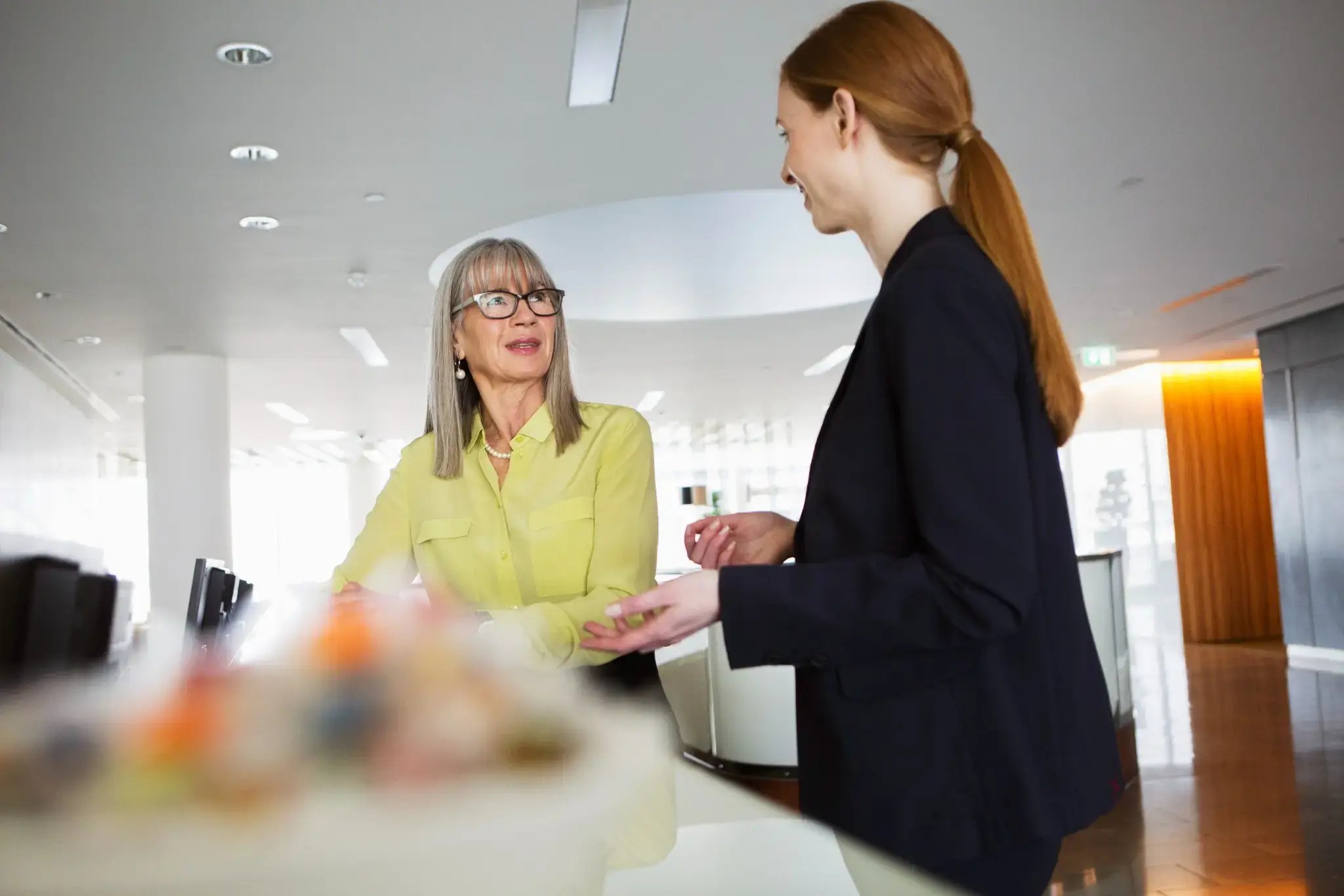 hotel-receptionist-talking-with-woman-in-modern-lobby